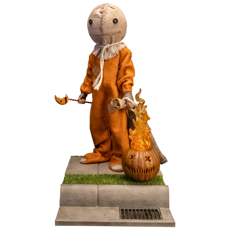 This is a Trick 'T Treat Sam 1:6 scale Figure and he has a burlap mask, orange jumpsuit, bitten lollipop, flaming pumpkin and sewer grate