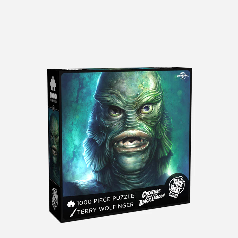 This is a Universal Monsters Puzzle of Creature From the Black Lagoon and he has a green face that looks like a fish, gills and teeth and it is the front of the box