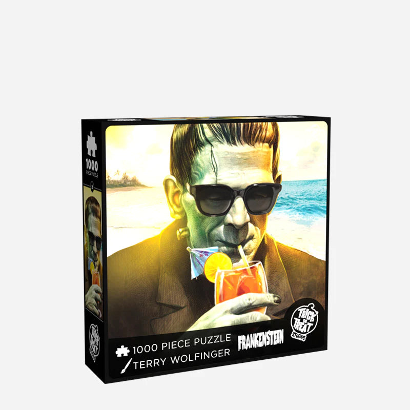 This is a Universal Monsters Frankenstein with beach and tropical drink puzzle and he has a green face, sunglasses, brown suit and dark hair and this is the front of the box