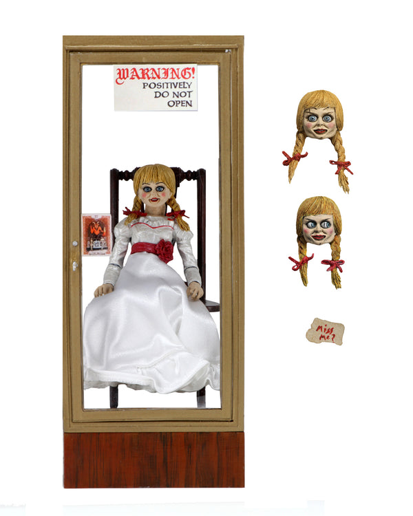 Annabelle from the Conjuring is sitting in a glass display case on a rocking chair and has 2 heads.