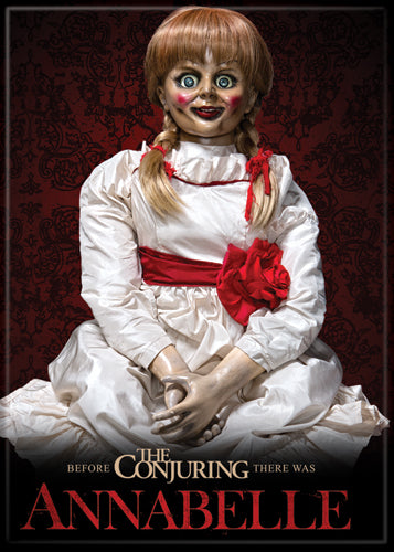 This is an Annabelle The Conjuring movie poster magnet and she has braided brown hair with red bows, a white dress with red flower and red cheeks
