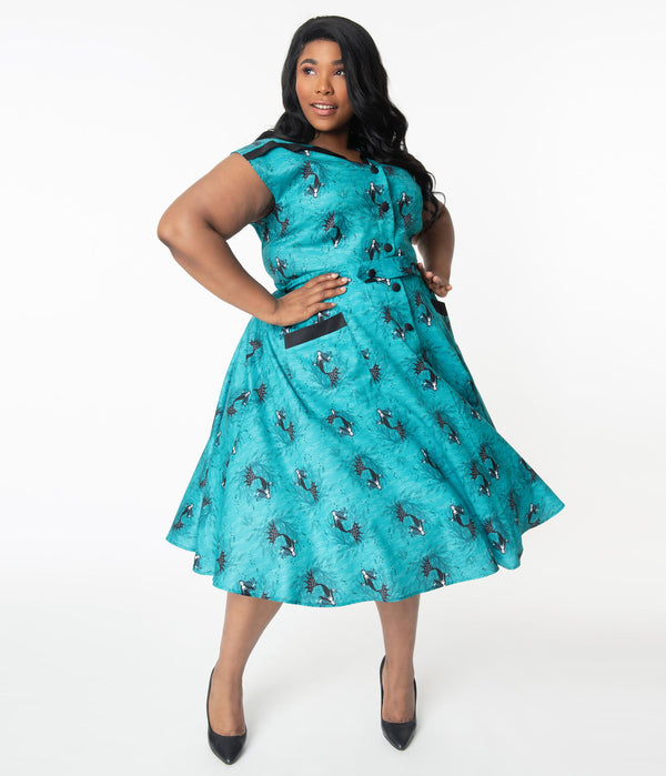 This is an aqua plus size vampire mermaid dress that has black buttons and pockets and the model is wearing black shoes.