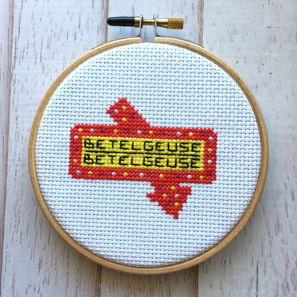 This is a Beetlejuice DIY cross stitch kit and it is a red and yellow sign that says Betelgeuse.
