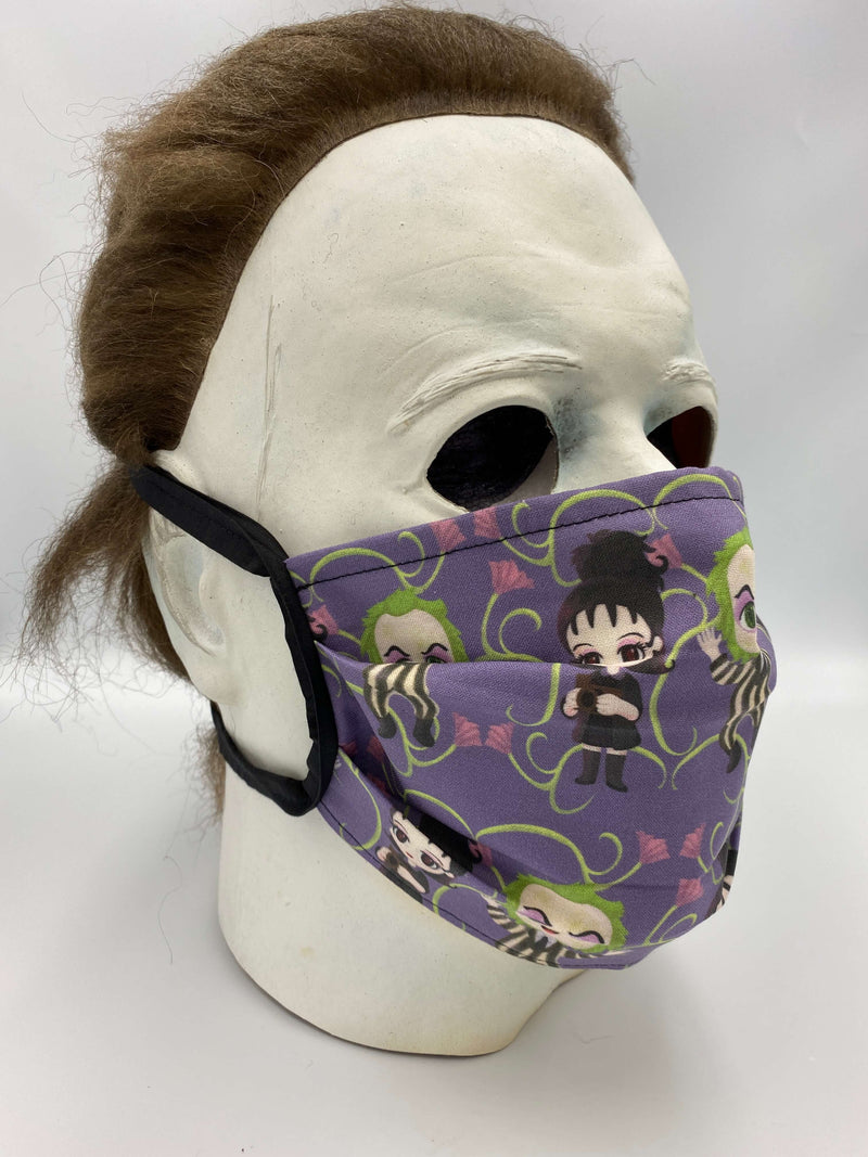 This is a purple Beetlejuice protective face mask that includes Lydia Deetz and had green vines with pink flowers and he has a black and white striped suit and it is on Michael Myers.