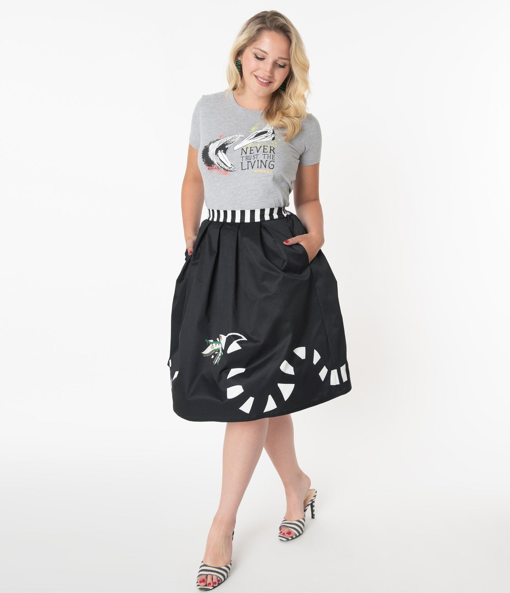 This is a Beetlejuice vintage pinup Sandworm swing skirt from Unique Vintage, that is black with a striped worm and the model is wearing a grey shirt and black and white striped shoes.