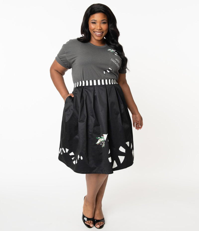 This is a Beetlejuice vintage pinup Sandworm swing skirt from Unique Vintage, that is black with a striped worm and the plus model is wearing a grey shirt and black shoes.