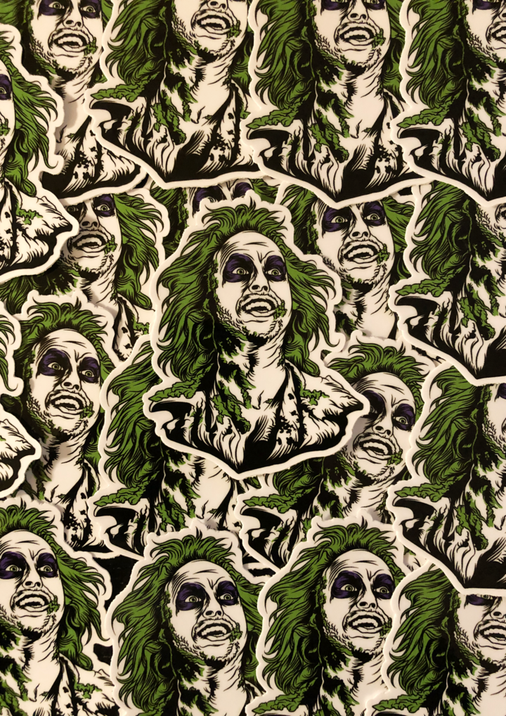 This is a collection of Beetlejuice head stickers and he has green hair, purple eyes and he has green on his face.