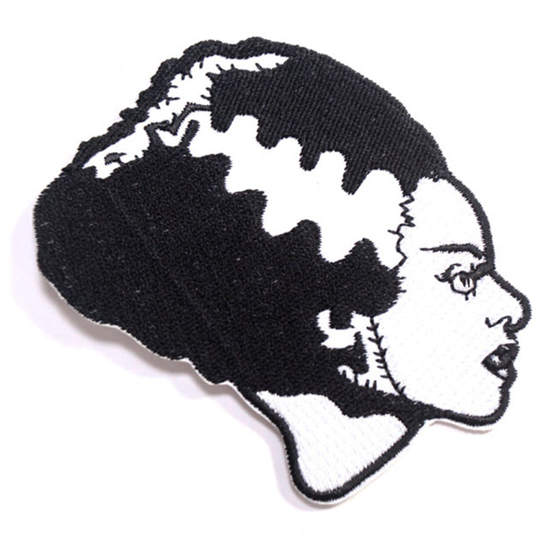 This is a Universal Monsters Bride of Frankenstein patch and she has black hair, with a white streak and stitch marks on her face.