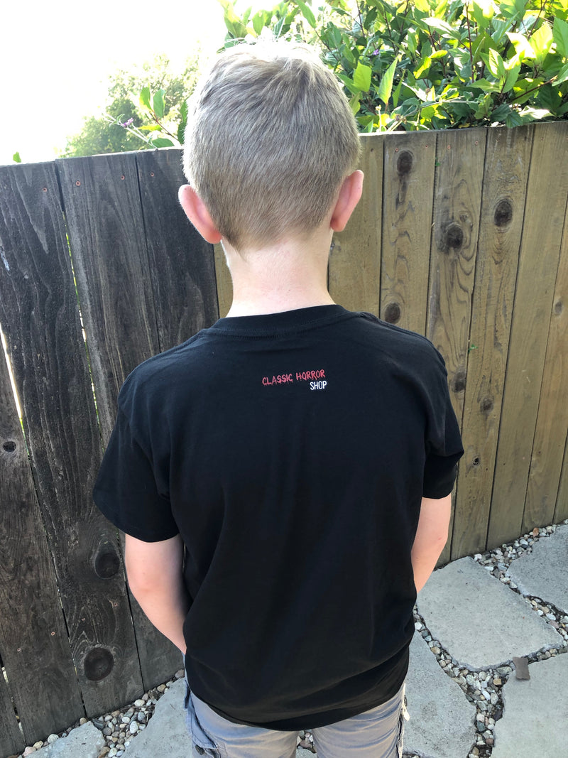 Kid with his back facing the camera wearing a black Classic Horror T-shirt
