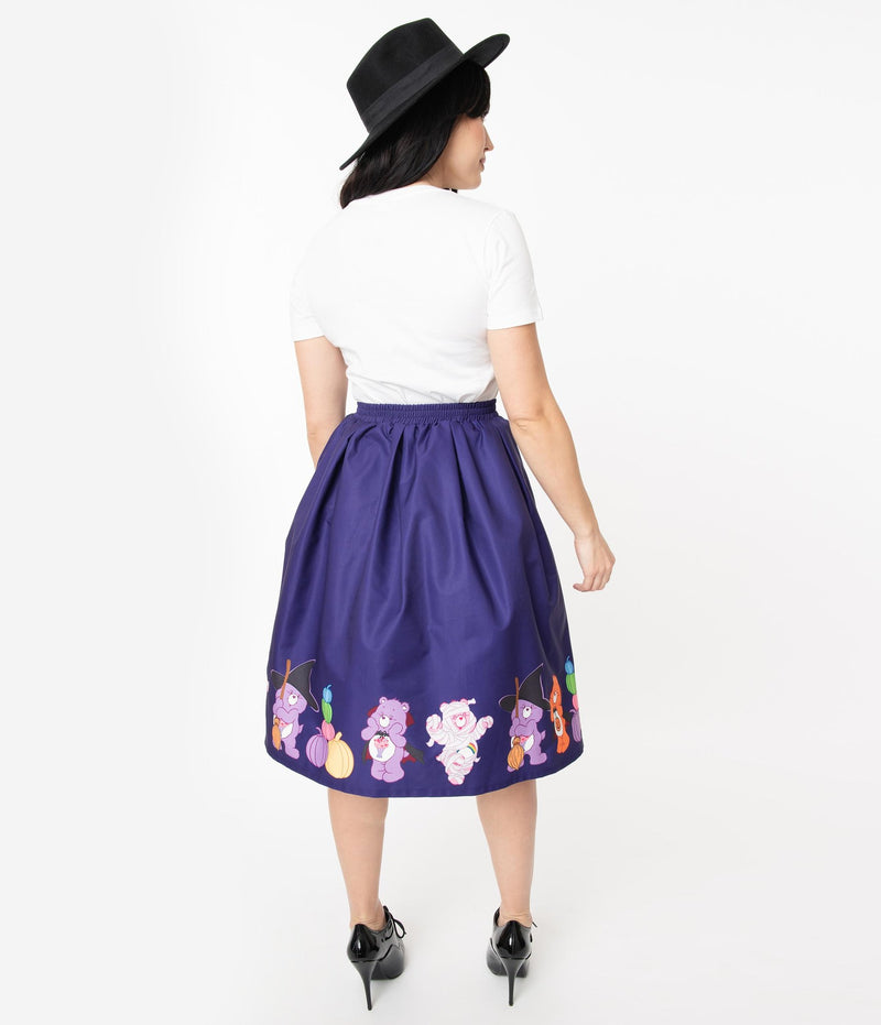 This is a Care Bears halloween purple Jayne swing skirt by Unique Vintage and the model is wearing a white shirt and has on black shoes and a black hat and her brown hair is to the side.