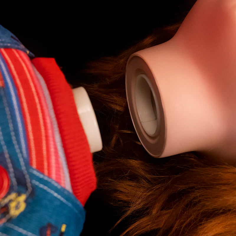 This is a Child's Play 2 Ultimate Chucky doll and he is wearing blue jean overalls, a striped long sleeve shirt, red shoes and he has orange hair and his head is detachable 