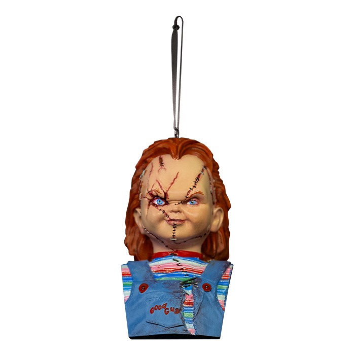 This is a Bride of Chucky ornament and he has orange hair, a striped shirt, blue overalls and stitches on his face.