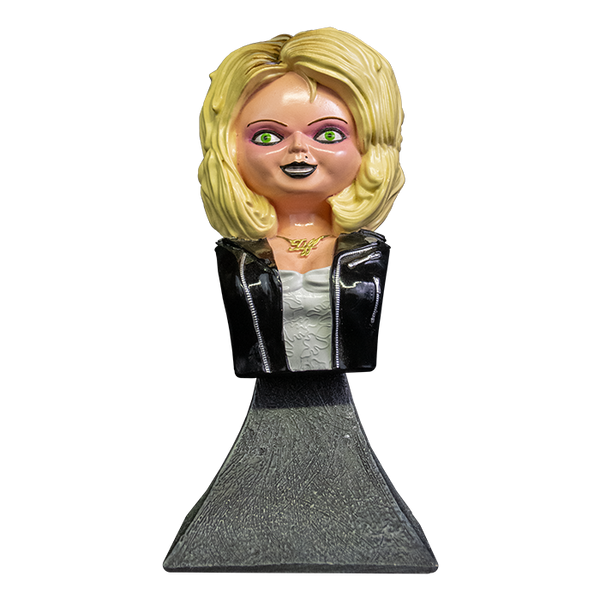 This is a Bride of Chucky Tiffany mini bust and she has blonde hair, a gold necklace, a black leather jacket with zippers, a white dress and a grey stand.