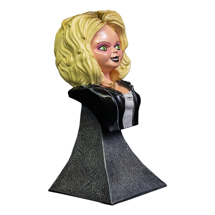 This is a Bride of Chucky Tiffany mini bust and she has blonde hair, a gold necklace, a black leather jacket with zippers, a wedding dress and a grey stand.