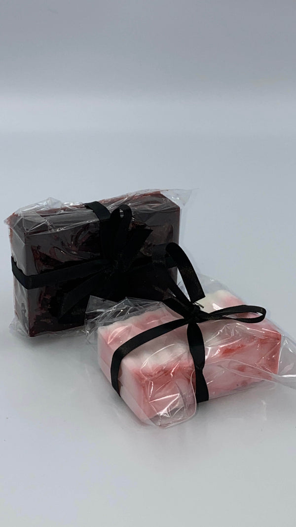 This is a hemp soap set containing one dark red soap in plastic, with a black ribbon and a white with red in plastic, with a black ribbon.