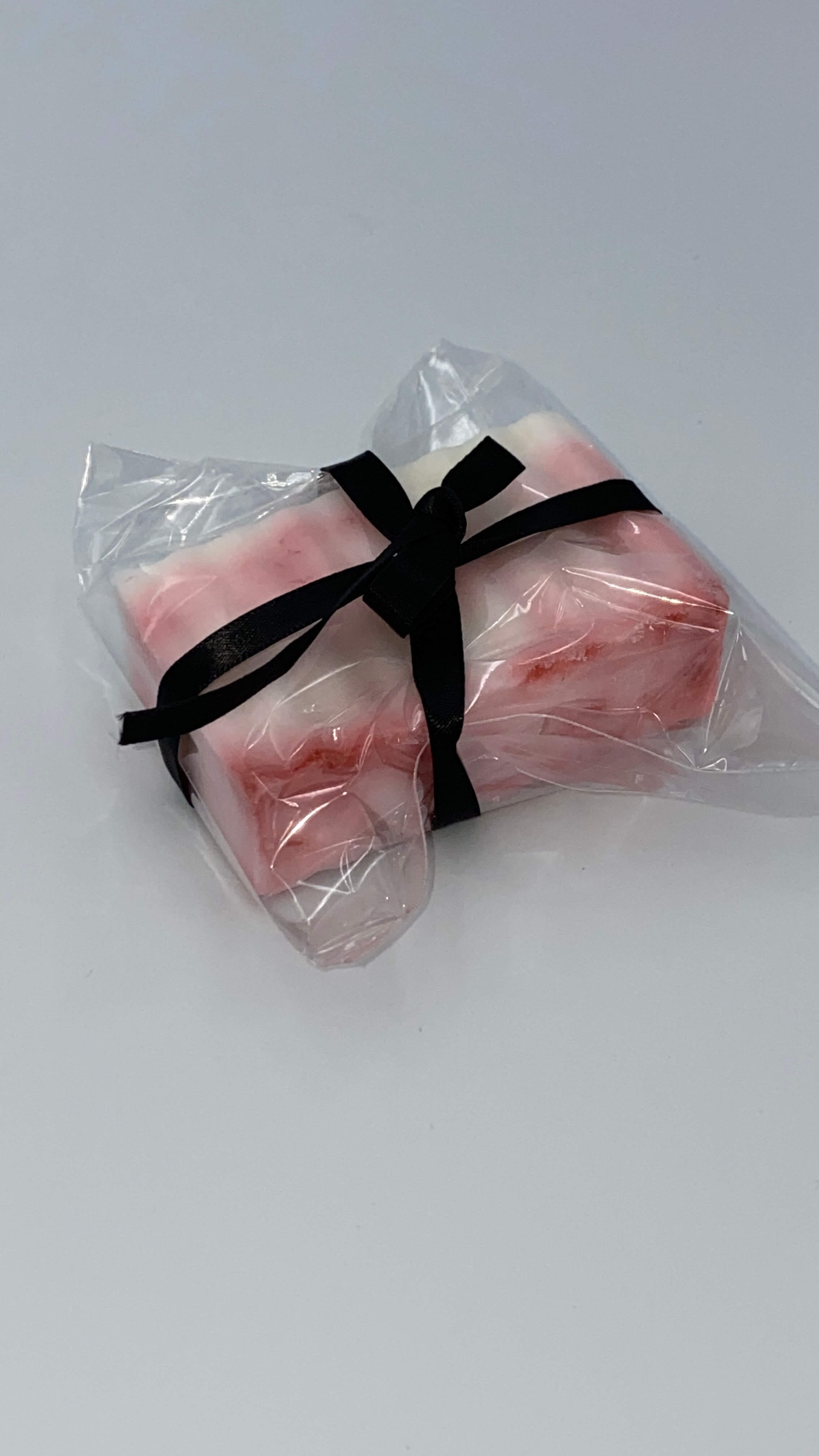 This is a white and bloody red hemp soap that is in a clear plastic, with a black ribbon.