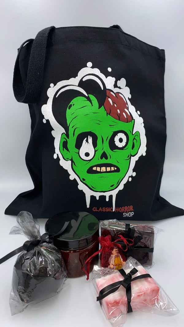 This is a bath and body set with a Classic Horror Shop zombie tote, bloody red scrub, red soap, white soap, black charcoal hemp bath bomb and a LEGO mini figure.