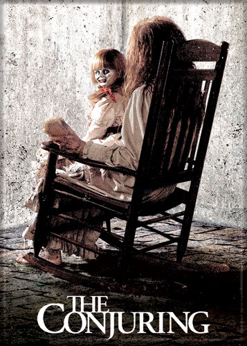 This is a Conjuring Annabelle magnet that is a creepy girl in a rocking chair with a doll wearing a white dress on her lap and with her head turned around.