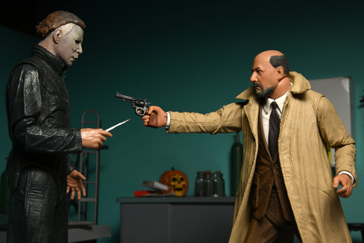 This is a NECA Halloween 2 Michael Myers and Loomis action figure set and Michael has a white mask, brown hair, green coveralls and is holding a scalpel and Loomis has a tan coat, brown suit, brown tie, holding a gun and there is an orange pumpkin.
