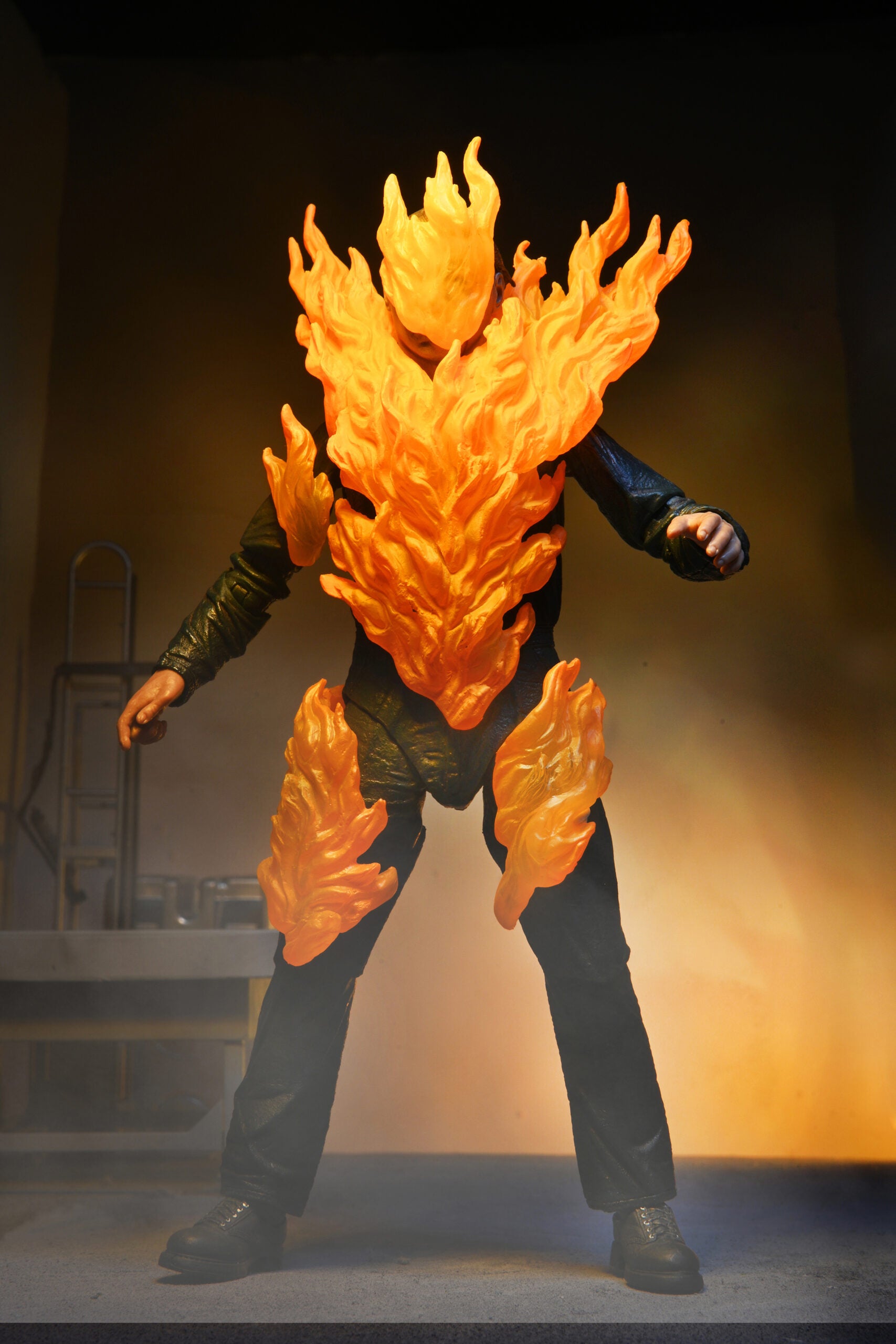 This is a NECA Halloween 2 Michael Myers and Loomis action figure set and Michael has a white mask, brown hair, green coveralls and is on fire.
