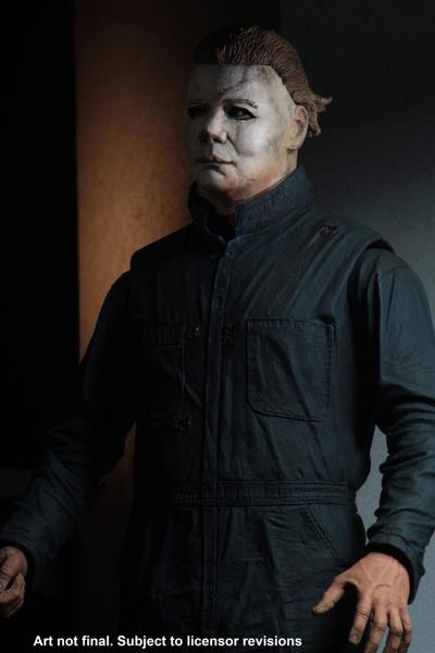This is a Halloween II Michael Myers NECA action figure and he is wearing a white mask with light brown hair, with green blue coveralls..