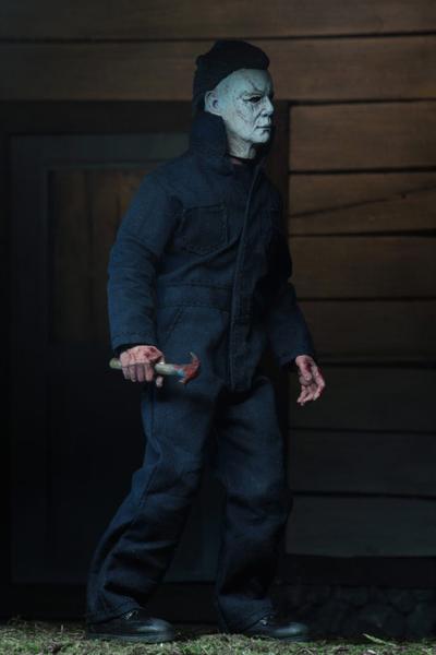 This is a NECA 8" clothed action figure from Halloween 2018 of Michael Myers, who is wearing a grey and weathered mask, grey coveralls and is holding a knife.