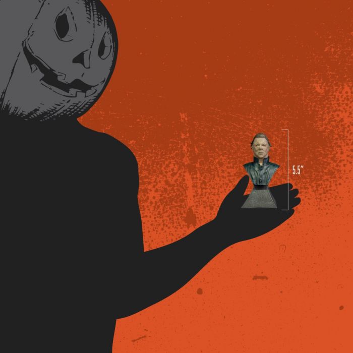 This is a Halloween II Michael Myers mini bust and he is wearing a mask, has brown hair and blue coveralls and is in a hand to show the height.