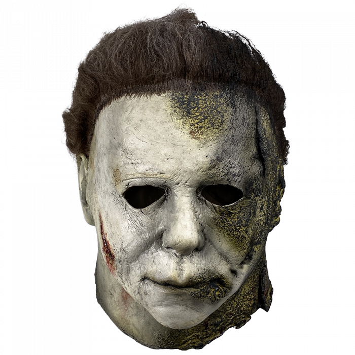 This is a Halloween Kills Michael Myers mask and he has a white face that has black burns and his brown hair is burnt.