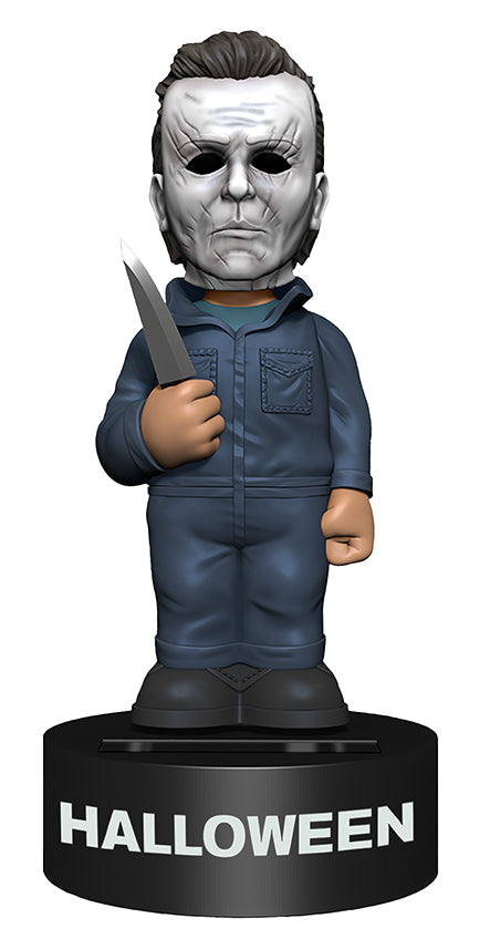 This is a 2018 Halloween Michael Myers Body Knocker from NECA and he has a grey coverall, a grey weathered mask with brown hair and is holding a silver knife.