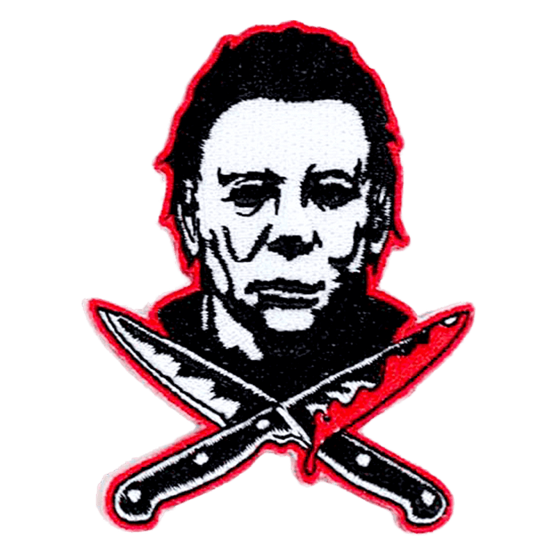 This is a Halloween Michael Myers patch that has a white face, dark hair and two bloody knives, that are crossed.