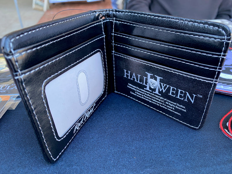This is the inside of a Halloween Michael Myers wallet that is black and has slots for cards and a clear plastic license holder.