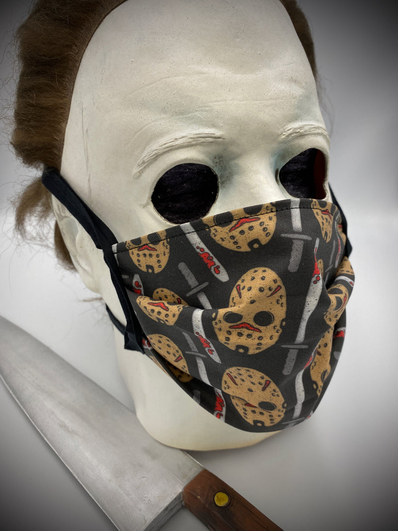 This is a black protective face mask with black ties and it is a Friday the 13th Jason Voorhees white hockey mask and a machete with blood on it, worn by Michael Myers.