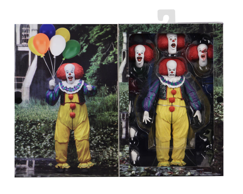 This is an It Movie 1990 NECA ultimate action figure package with Pennywise who has a white face, red nose, orange red hair, yellow suit with orange balls and green and purple stripes