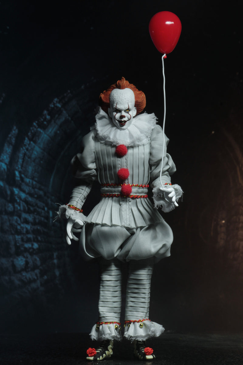This is an It Movie 2017 Pennywise NECA action figure and he has orange hair, grey suit with red balls, white face, yellow eyes, red balloon  and he is in a sewer.