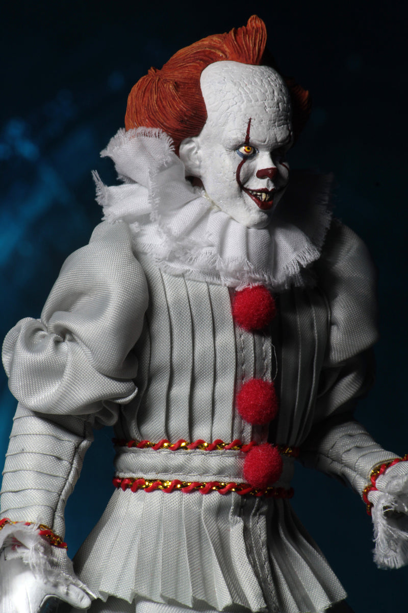 This is an It Movie 2017 Pennywise NECA action figure and he has orange hair, grey suit with red balls, white face, yellow eyes, white fluffy collar and he is smiling. 