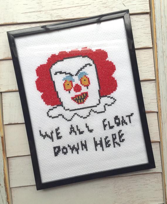 This is a Pennywise the clown It Movie DIY cross stitch kit and he has red hair, yellow eyes, white collar and it says we all float down here.