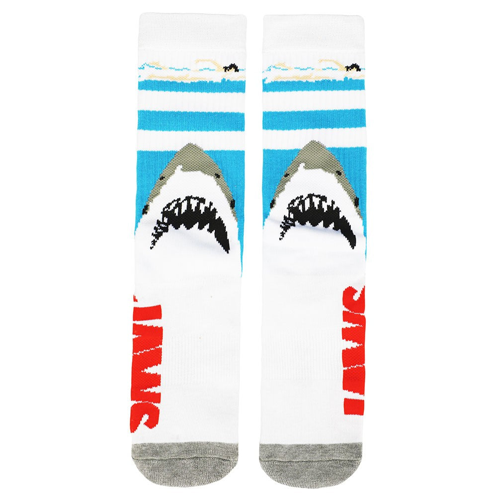 This is a pair of Jaws crew socks and there is a girl swimming in the blue water and a shark with pointy teeth below her.