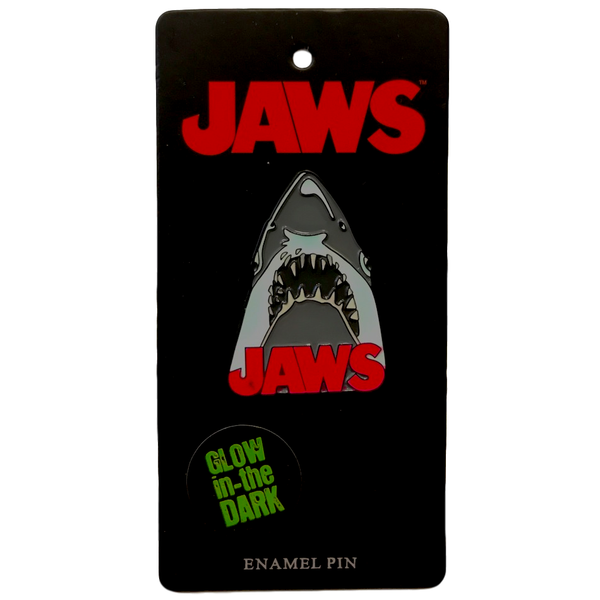 This is a Jaws enamel pin and he is grey with sharp teeth and the logo is in red font.