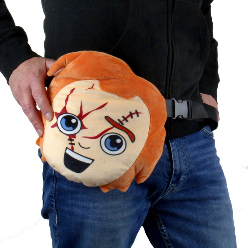 This is a Child's Play Chucky Kidrobot Phunny plush fanny pack bag and he has orange hair, cuts, stitches and an adjustable black strap and he is on a man who is wearing jeans and a black hoodie.