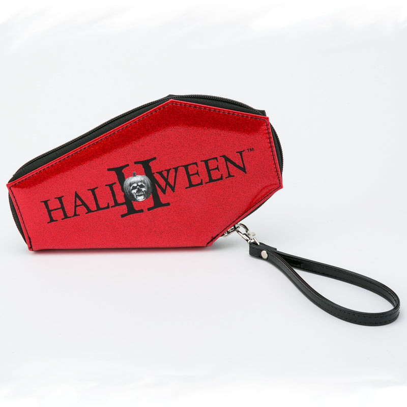This is a Halloween Michael Myers coffin shaped wallet and it has red glitter, a pumpkin and a black wrist strap.