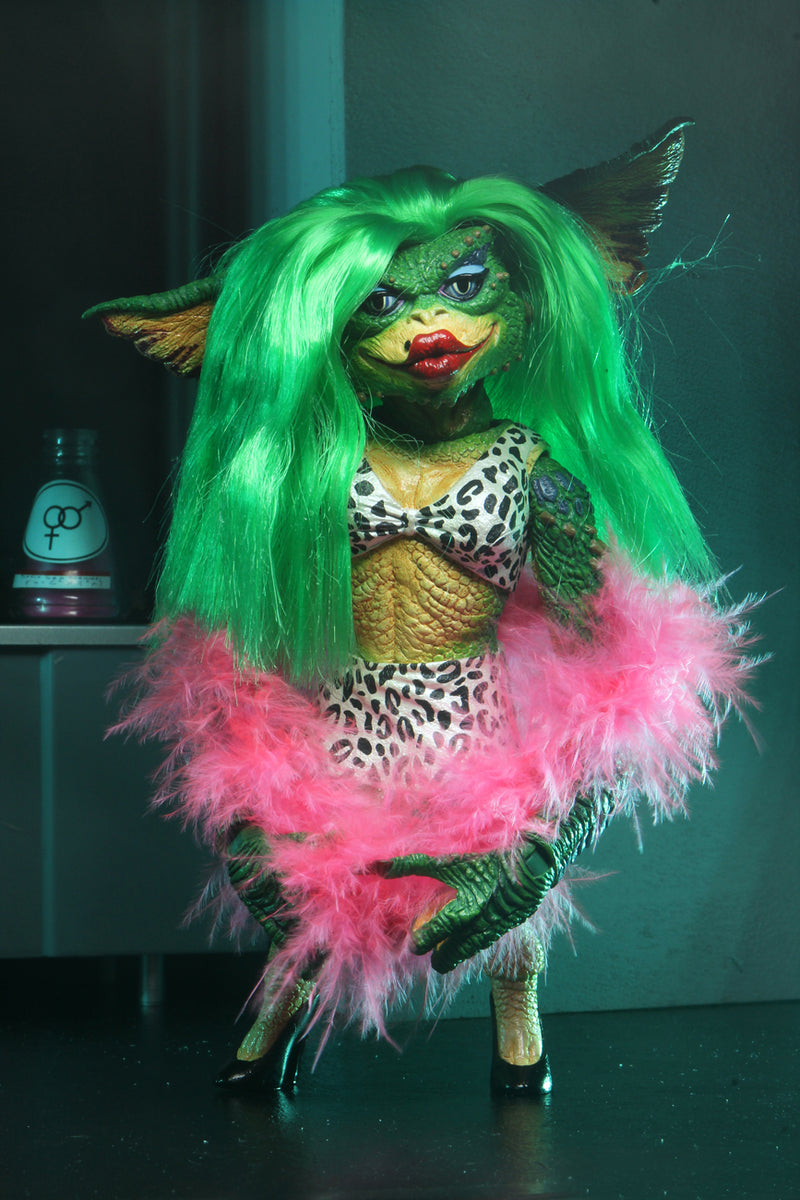This is a NECA Gremlins 2 Greta 7" Ultimate action figure and she has long green hair, a pink boa, black and white animal print top and black heels.
