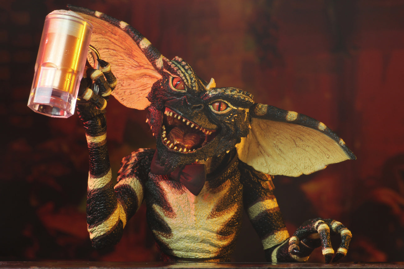This is a NECA Gremlins flasher ultimate action figure and he is holding a draft beer in a clear mug.