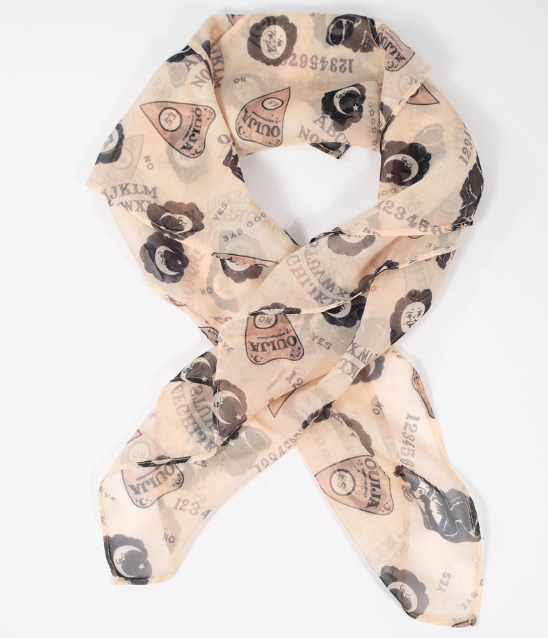 This is a Ouija chiffon hair scarf that is tan with moons and planchettes.