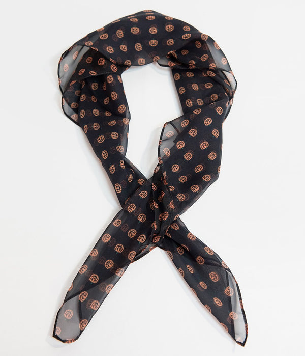 This is a black pinup style chiffon hair scarf that has orange pumpkins on it.