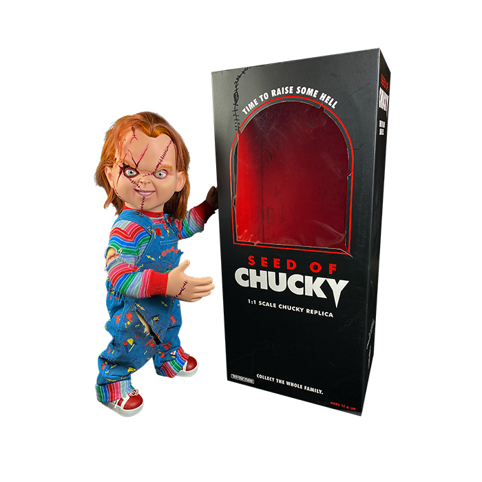 This is a Seed of Chucky life sized doll and he has blue overalls, striped shirt, orange hair, scars and stitches on his face and red shoes and he is with a black box with red and white letters.. 