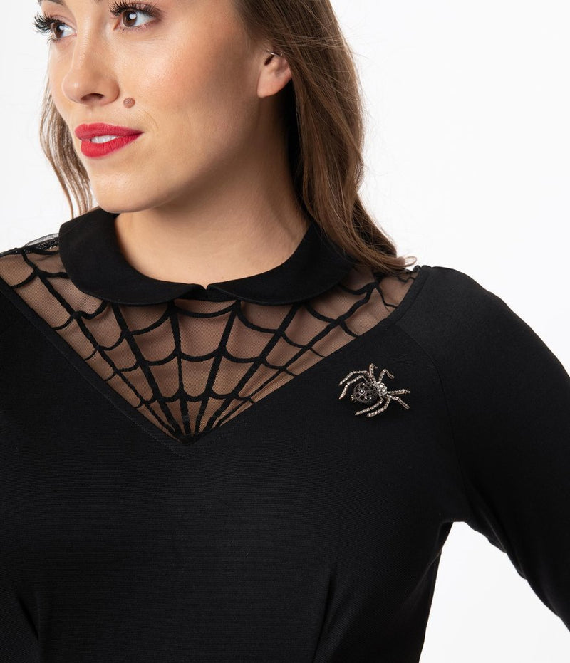 This is a black Unique Vintage flare dress that has a spiderweb neck, Peter Pan collar, 3/4 sleeves and a silver jewel spider.