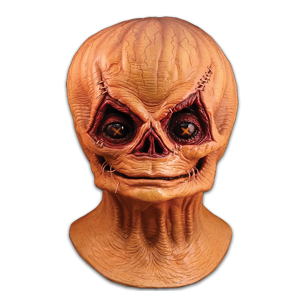 This is a Trcik 'r Treat Sam unmasked mask and he has tan skin with big, cutout eyes with a wide mouth.