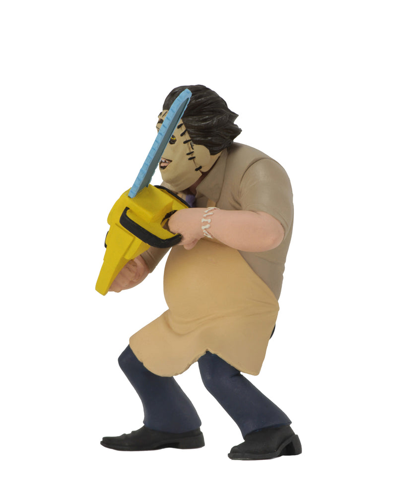 Leatherface Tooney Terror is standing in front of a white background in a 1974 killing mask, while wearing a yellow apron and holding a yellow chainsaw.