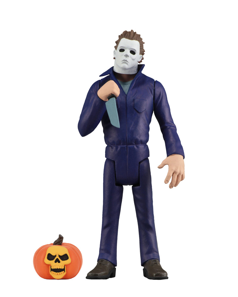 Michael Myers action figure is standing in blue coveralls with a white background, holding a knife, with a pumpkin at his feet.