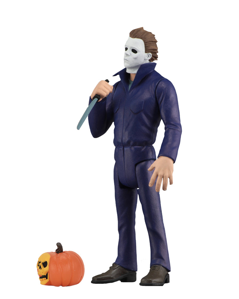 Michael Myers NECA action figure is standing in blue coveralls with a white background, holding a knife, with a pumpkin at his feet.
